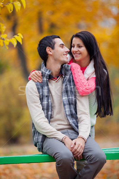 photo of cute couple sitting on the bench on the wonderful autum Stock photo © Massonforstock