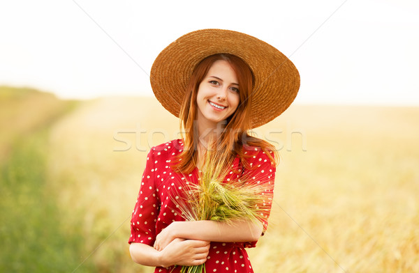Redhead girl in red dress at wheat field Stock photo © Massonforstock