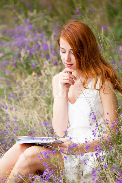 photo of beautiful young woman with copybook sitting on the gras Stock photo © Massonforstock