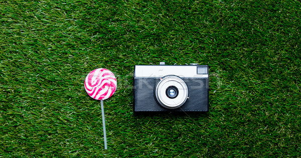 Vintage camera and lollipop candy on green grass background Stock photo © Massonforstock