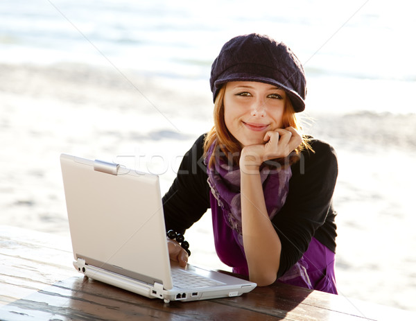 Portrait of red-haired girl with laptop at beach. Stock photo © Massonforstock