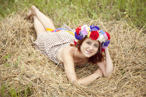 Girl in Slav national wreath lying at field. Stock photo © Massonforstock