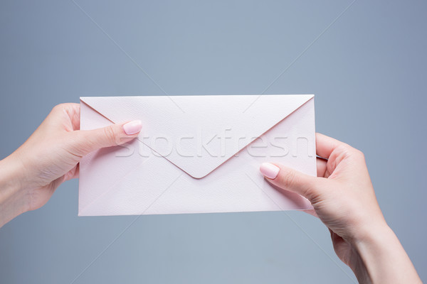 The female hands with envelope against the gray background Stock photo © master1305