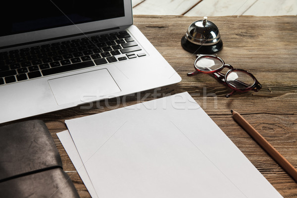 Laptop papel em branco óculos pequeno sino mesa de madeira Foto stock © master1305