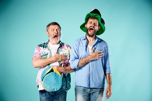 Stock photo: The two football fans singing the national anthem over blue