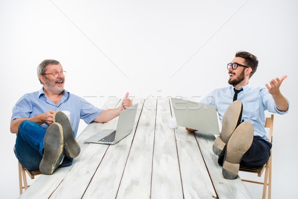 The two businessmen with legs over table working on laptops Stock photo © master1305