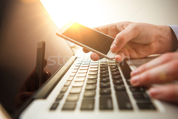 Férfi kéz tart telefon iroda laptop Stock fotó © master1305