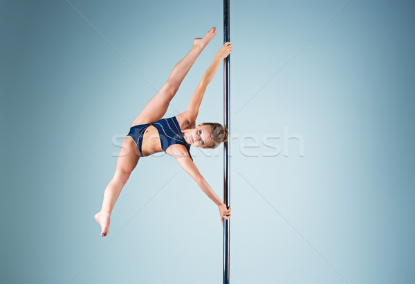 The strong and graceful young girl performing acrobatic exercises on pylon Stock photo © master1305