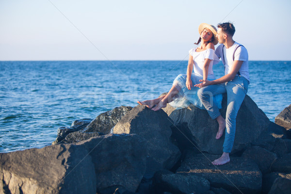 Stock photo: Happy young romantic couple relaxing on the beach watching the sunset