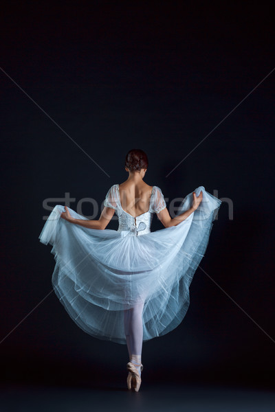 Stock photo: Portrait of the classical ballerina in white dress on black background