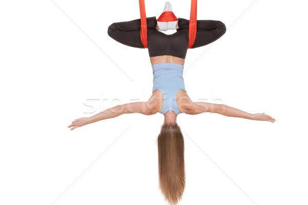 Young woman doing anti-gravity aerial yoga in hammock on a seamless white background. Stock photo © master1305