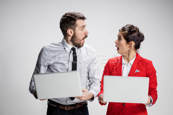 The young businessman and businesswoman with laptops  communicating on gray background Stock photo © master1305