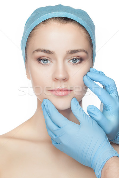 Plastic surgery concept. Doctor hands in gloves touching woman face Stock photo © master1305