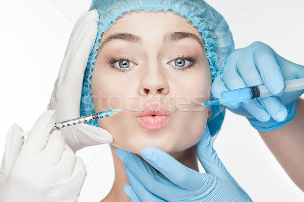 Attractive woman at plastic surgery with syringe in her face Stock photo © master1305