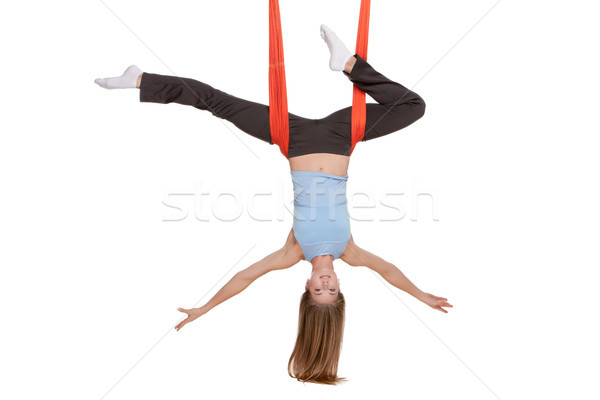Young woman doing anti-gravity aerial yoga in hammock on a seamless white background. Stock photo © master1305