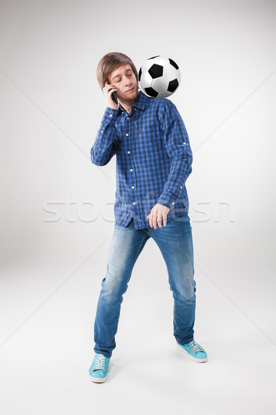 The portrait of fan with ball, holding phone on white background Stock photo © master1305