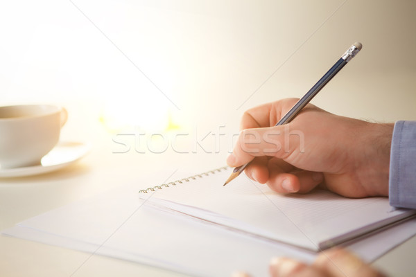 Stock photo: The male hand with a pencil and the cup