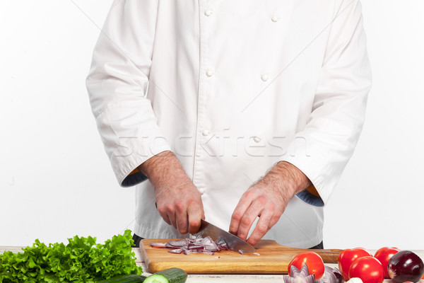 Stock photo: Chef cutting a onion on his kitchen