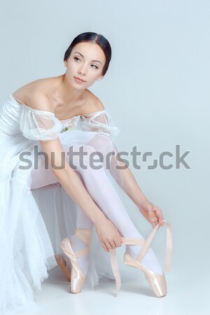 Ballerina in white dress sitting, studio background. Stock photo © master1305