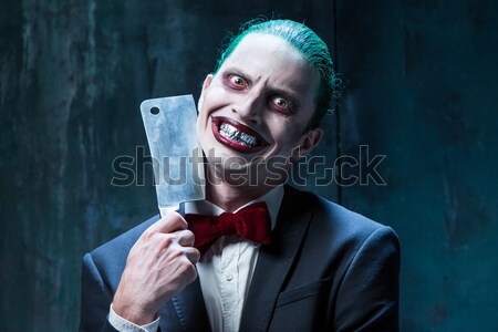 Stock photo: The scary clown holding a knife on dack. Halloween concept