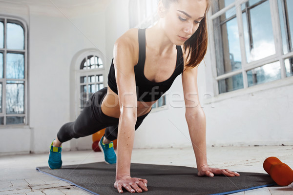 Beautiful slim brunette  doing some push ups a the gym Stock photo © master1305