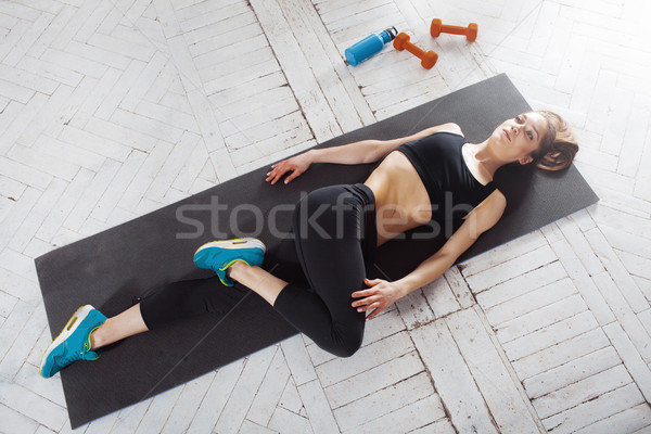 Beautiful slim brunette  doing some stretching exercises in a gym Stock photo © master1305