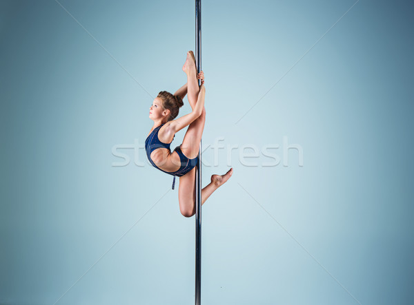 The strong and graceful young girl performing acrobatic exercises on pylon Stock photo © master1305