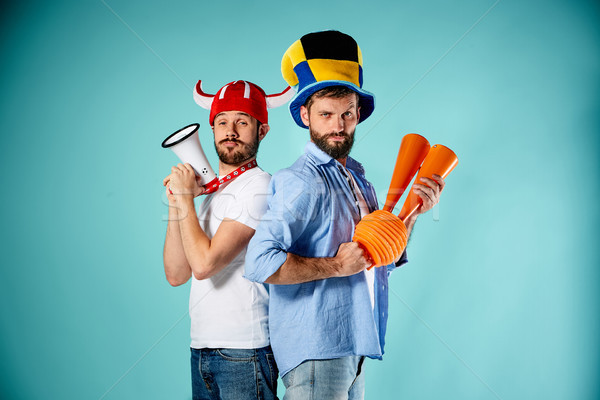 The two football fans with mouthpiece over blue Stock photo © master1305