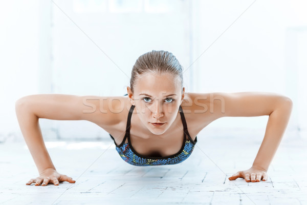 Beautiful slim brunette doing some push ups a the gym Stock photo © master1305