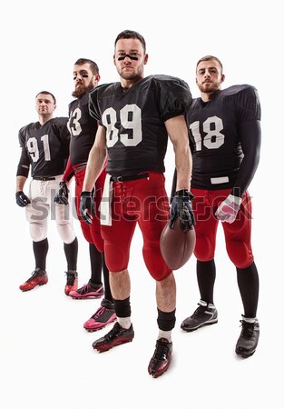 Stock photo: The four american football players posing with ball on white background