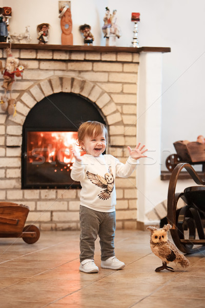 Happy child little girl standing at home against fireplace Stock photo © master1305