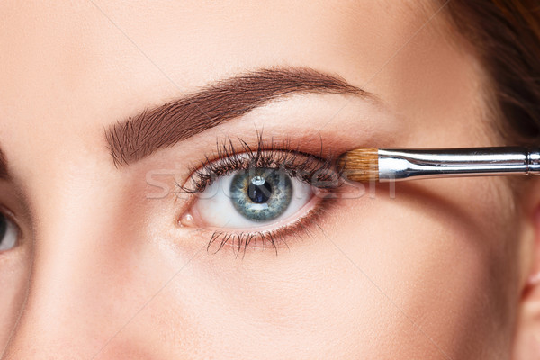 Beautiful female eyes with bright blue make-up and brush Stock photo © master1305