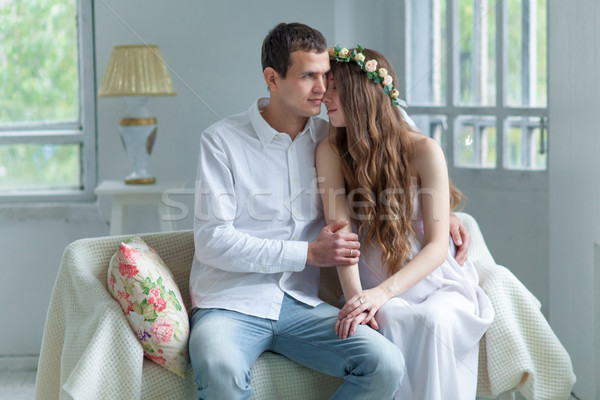 Cheerful young couple  dressed in white sitting on sofa  Stock photo © master1305