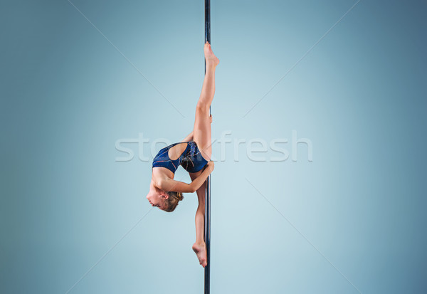 The strong and graceful young girl performing acrobatic exercises on pylon Stock photo © master1305