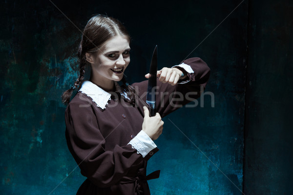 Stock photo: Portrait of a young girl in school uniform as killer woman