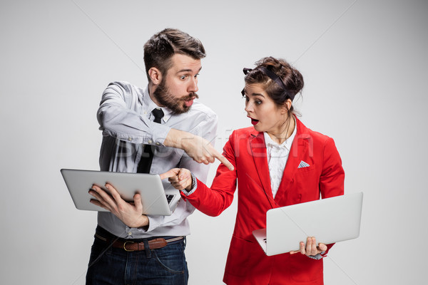 The young businessman and businesswoman with laptops  communicating on gray background Stock photo © master1305