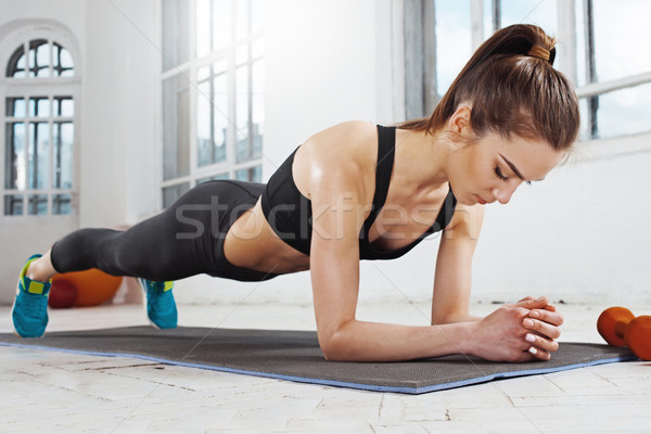 Beautiful slim brunette  doing some push ups a the gym Stock photo © master1305