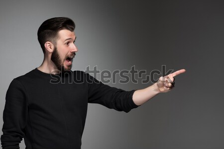 Excited man pointing a great idea - over gray background Stock photo © master1305