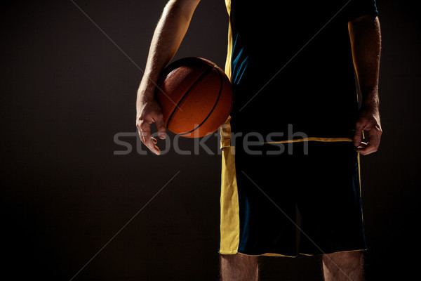 Silhouette view of a basketball player holding basket ball on black background Stock photo © master1305