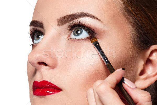 Beautiful female eyes with bright blue make-up and brush Stock photo © master1305