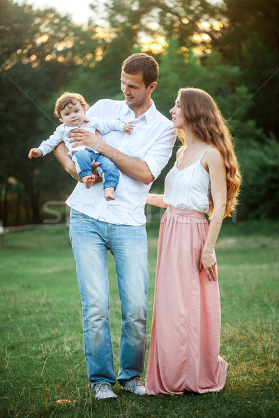 Young beautiful father, mother and little toddler son against green trees Stock photo © master1305