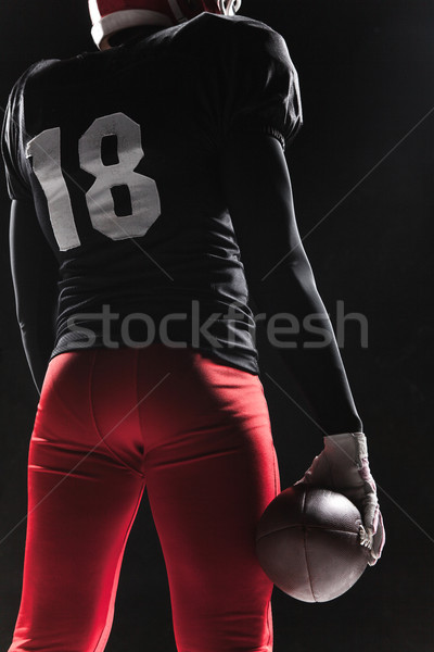 American football player posing with ball on black background Stock photo © master1305