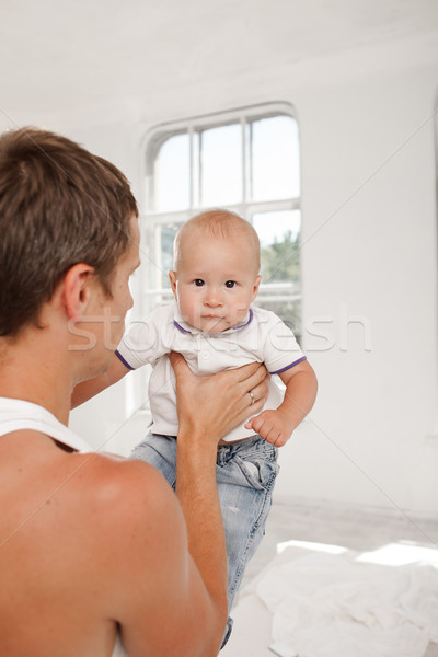 Stock photo: young father with his nine months old son on the bed at home