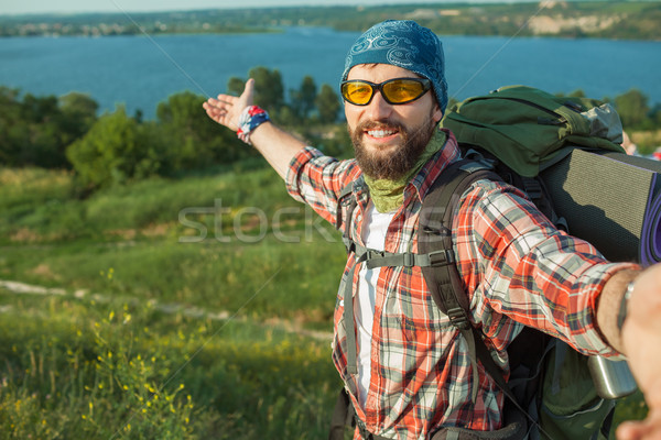 Young caucasian man with backpack standing on the top of hill Stock photo © master1305