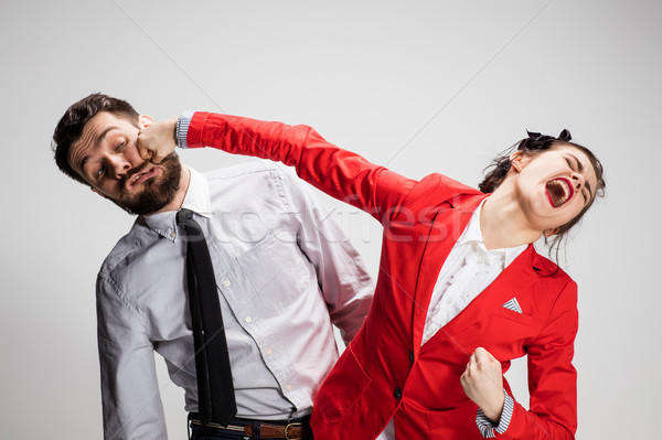 The angry business man and woman conflicting on a gray background Stock photo © master1305