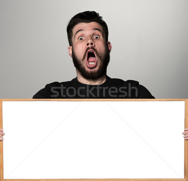 The surprised man and empty blank over gray background Stock photo © master1305