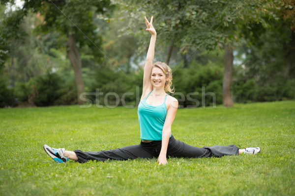 Beautiful young woman doing stretching exercises in the park. Stock photo © master1305