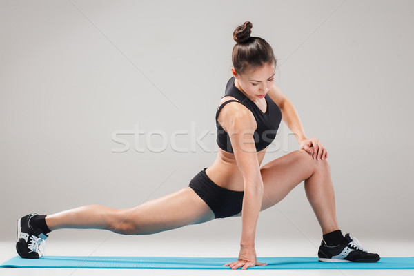 Beautiful sporty girl standing in acrobat pose or yoga asana Stock photo © master1305