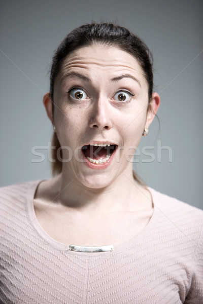 Stock photo: Portrait of young woman with shocked facial expression