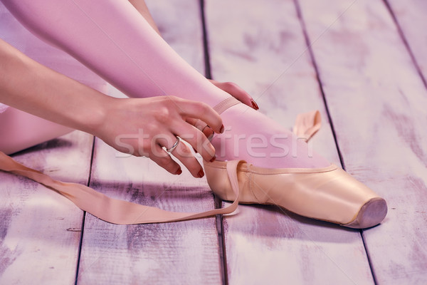 Stock photo: Professional ballerina putting on her ballet shoes.